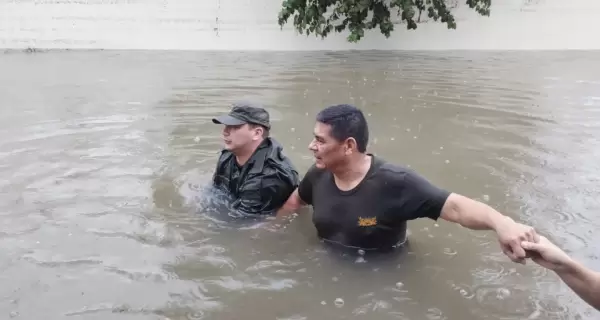 Un oficial de Prefectura ayuda a un vecino de la ciudad de Corrientes durante las inundaciones.