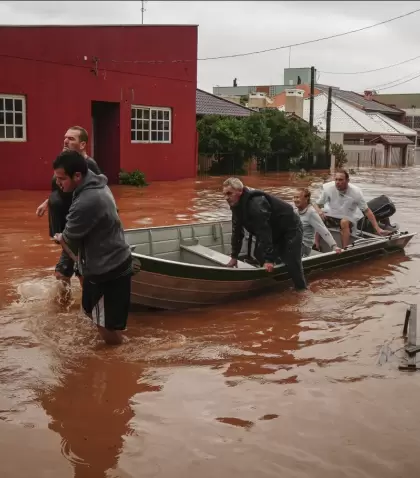 Personas evaca una zona inundada despus de fuertes lluvias en Sao Sebastiao do Cai, estado de Rio Grande do Sul, Brasil, el jueves 2 de mayo de 2024