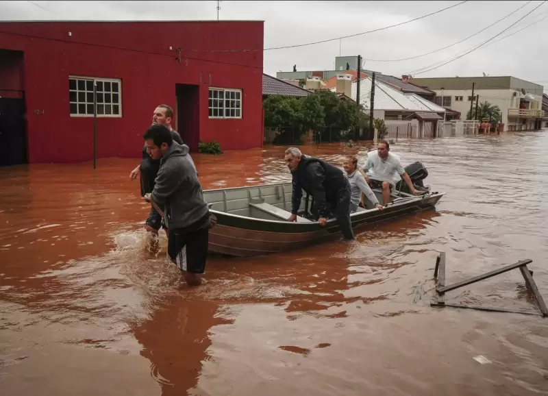 Personas evaca una zona inundada despus de fuertes lluvias en Sao Sebastiao do Cai, estado de Rio Grande do Sul, Brasil, el jueves 2 de mayo de 2024