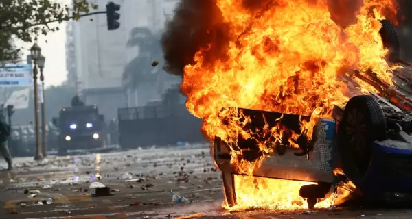 Un auto incendiado por un grupo de manifestantes en las afueras del Congreso durante el tratamiento de la Ley Bases y el paquete fiscal en el Senado.
