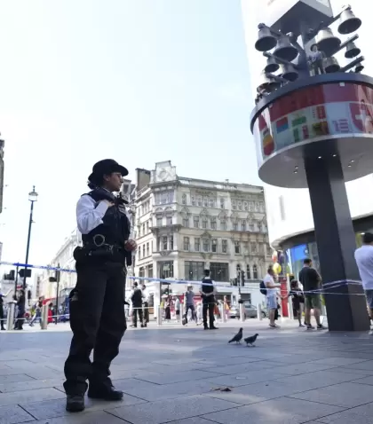 Una polic�a frente a la escena del crimen en Leicester, Londres