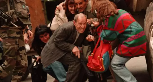 Habitantes de Sarajevo buscan cubrirse de los disparos de un francotirador, el 8 de junio de 1995.